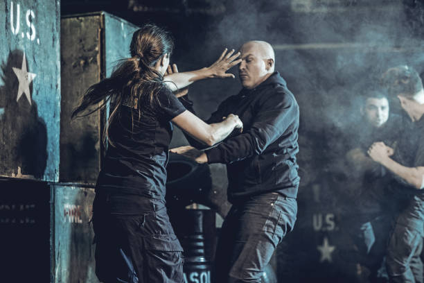 Krav Maga fighting group training in dark indoor urban setting