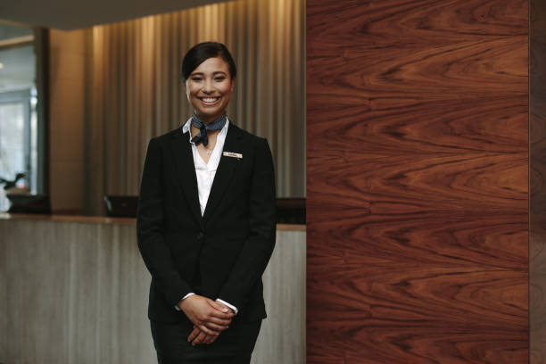 Portrait of happy female hotel receptionist standing at workplace. Smiling woman receptionist working in hotel.