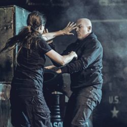 Krav Maga fighting group training in dark indoor urban setting